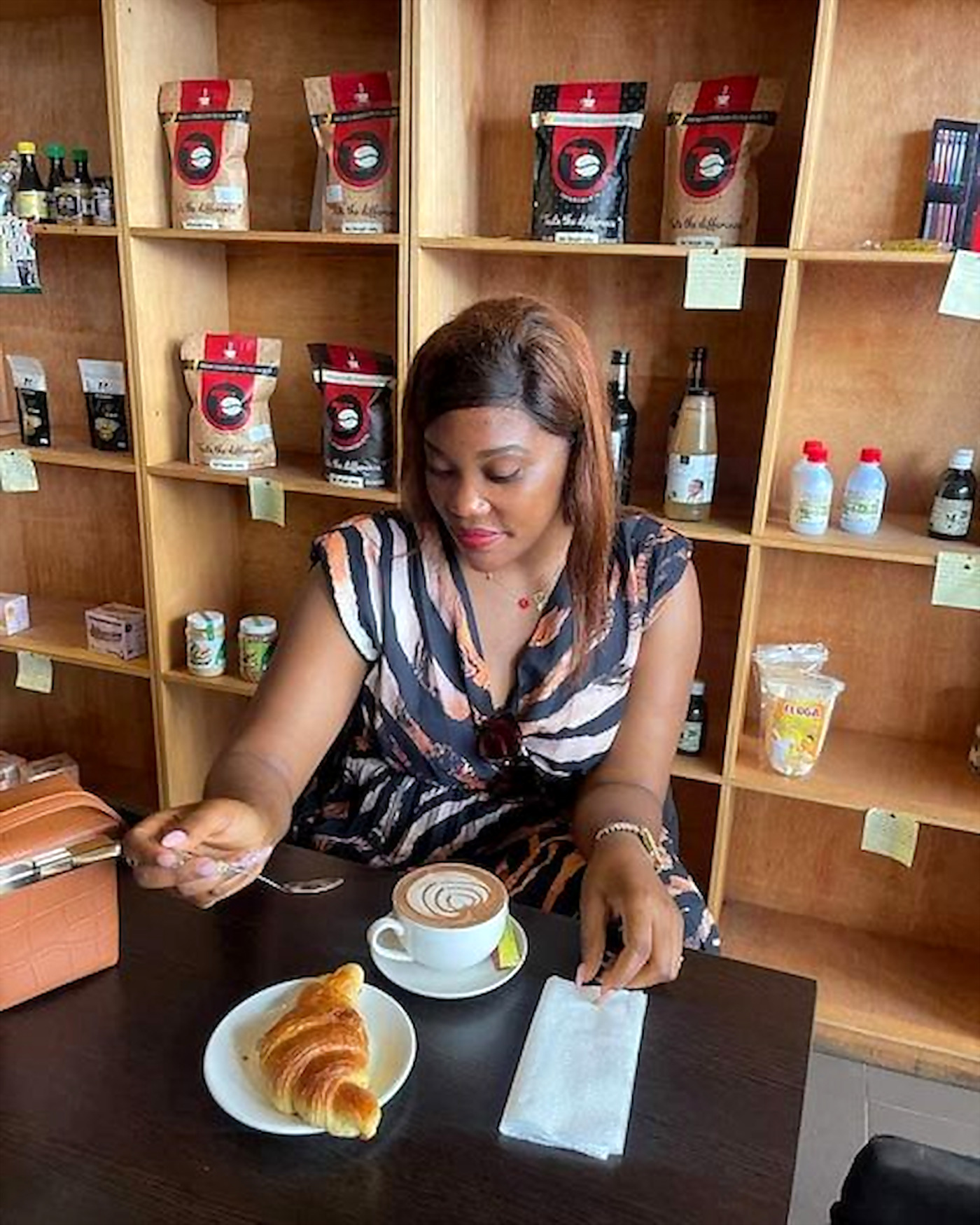Une cliente au comptoir Terrific Coffee, devant les paquets de café